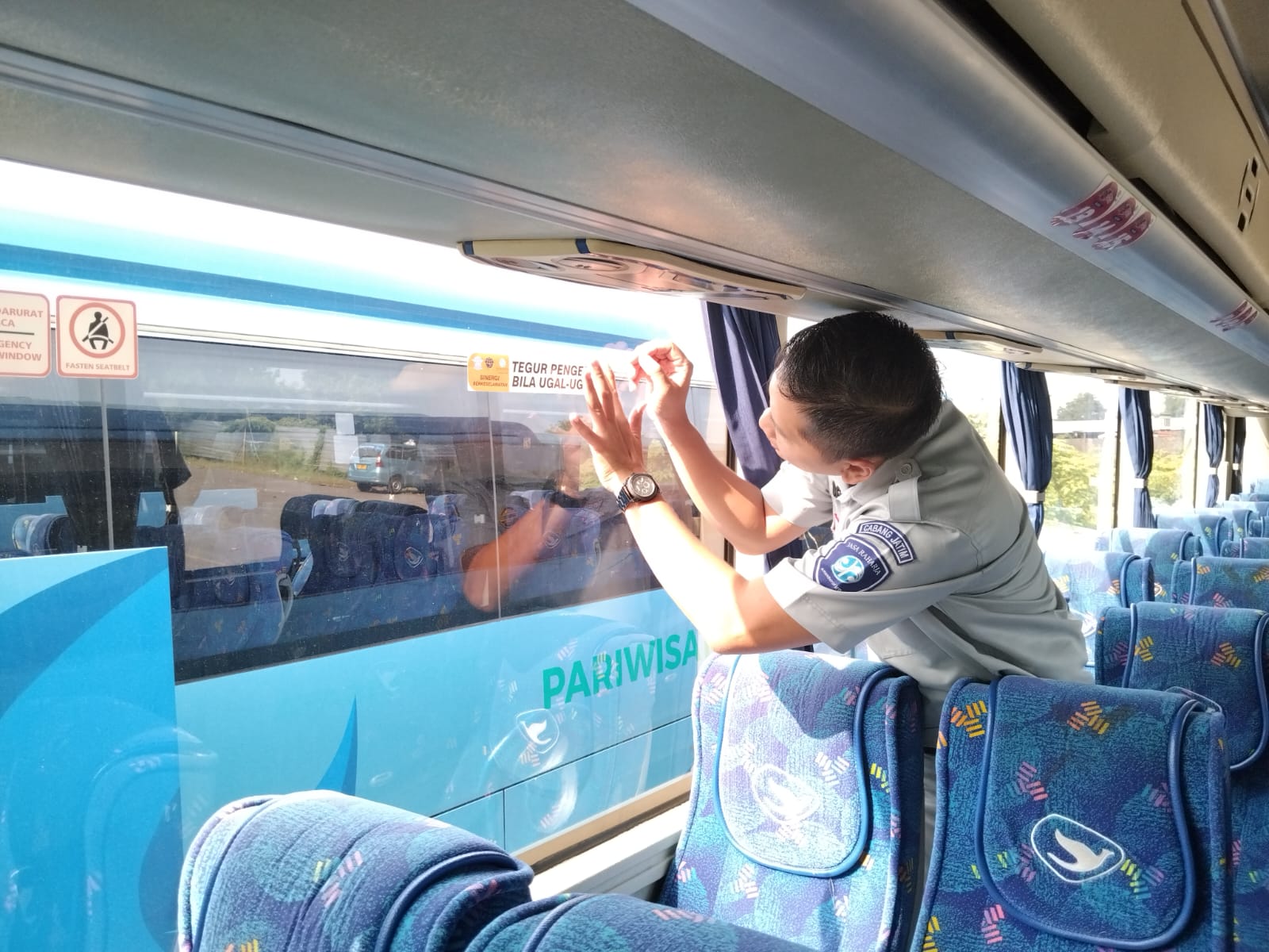 Penumpang bus menerima brosur keselamatan dari petugas