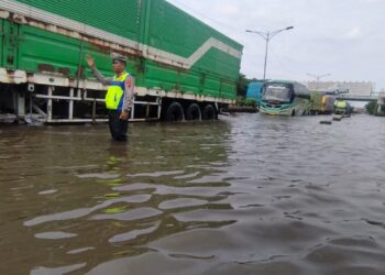 Tidak Hanya Lakukan Pengalihan Arus Lalin, Polrestabes Semarang Bantu Warga Lintasi Genangan Air Kaligawe-Genuk