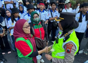Polwan Negosiator Polda Jateng Bagikan Bunga Sebagai Wujud Empati Perjuangan Buruh Selama Aksi May Day di Kantor Gubernur Jateng